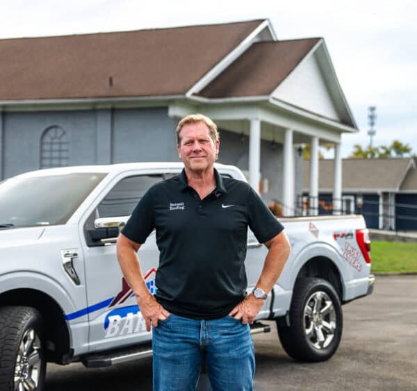 Owner, David Barnett standing in front of a Barnett Roofing truck